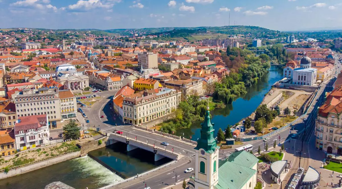 Centrul orașului Oradea văzut de sus, este soare afară și copacii au frunze verzi, clădirile sunt luminate de razele soarelui