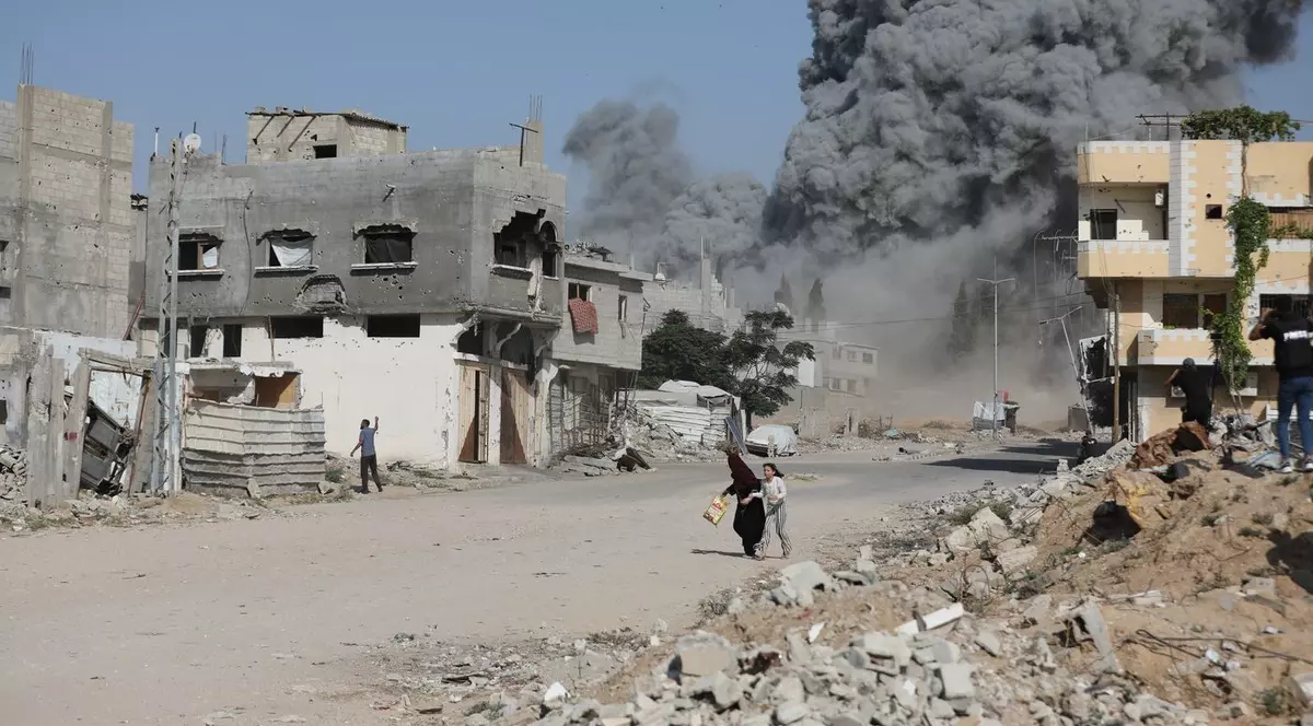 Două femei fug pentru a se salva după o explozie. Clădirile din Gaza, distruse atât de bombardamente, cât și de explozii planificate. Imagine cu caracter ilustrativ Foto: Profimedia