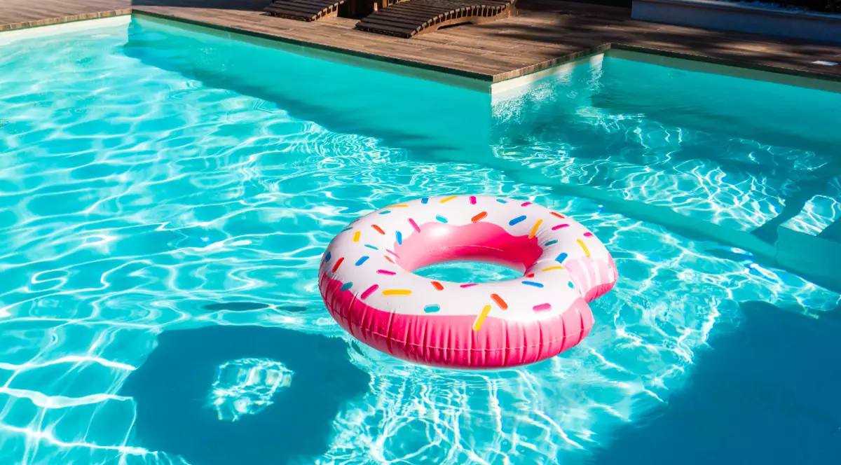 Un colac roz care plutește în piscină