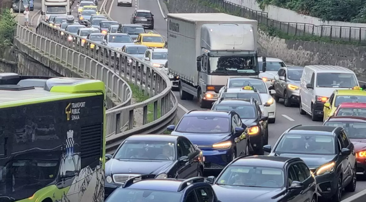 În imagine se observă autobuze ale transportului public local prinse în ambuteiaj, taxiuri care încearcă să se strecoare printre benzi și camioane staționate, fără posibilitate de manevră