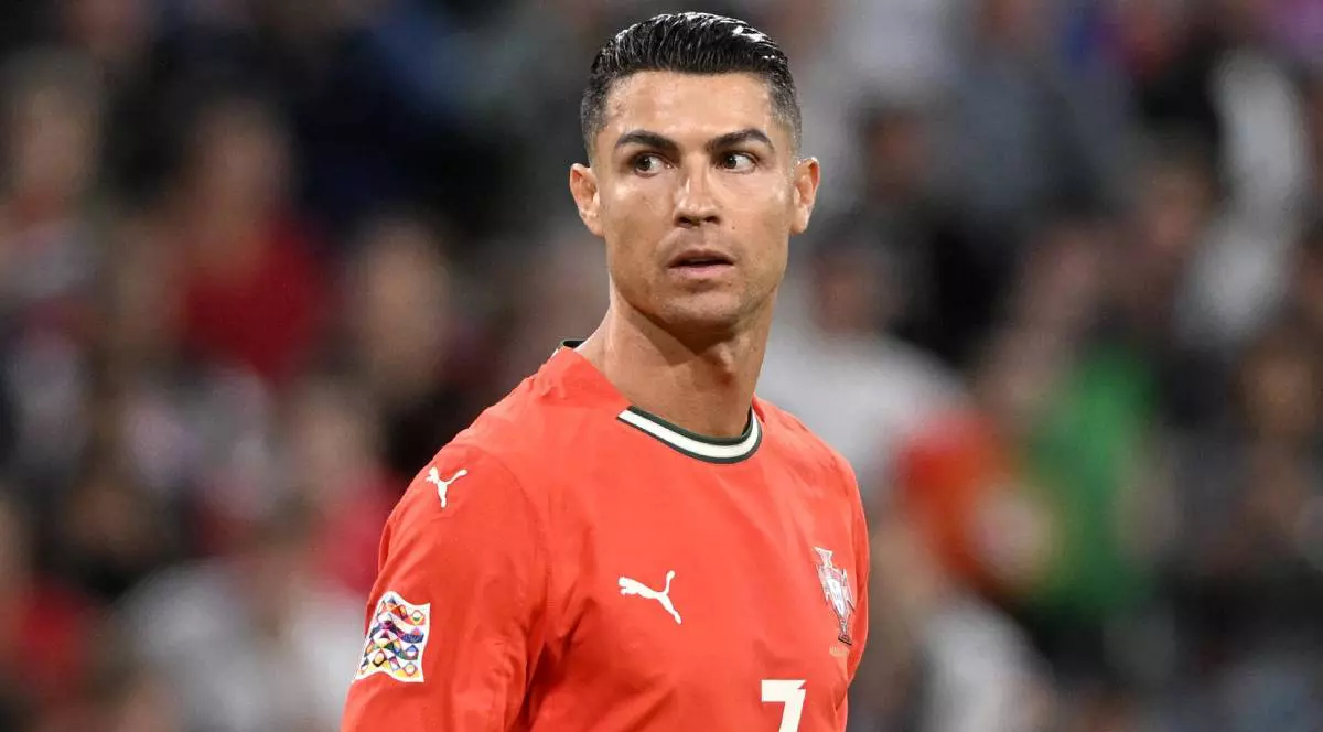 Cristiano Ronaldo pe terenul de fotbal, poartă un echipament roșu