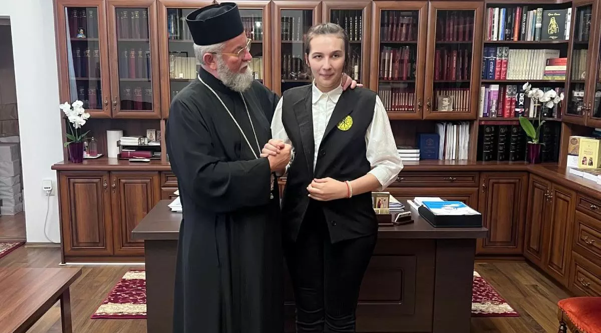 Cristina Conț. elevă nevăzătoare din Baia Mare , alături de Preasfințitul Părinte Iustin