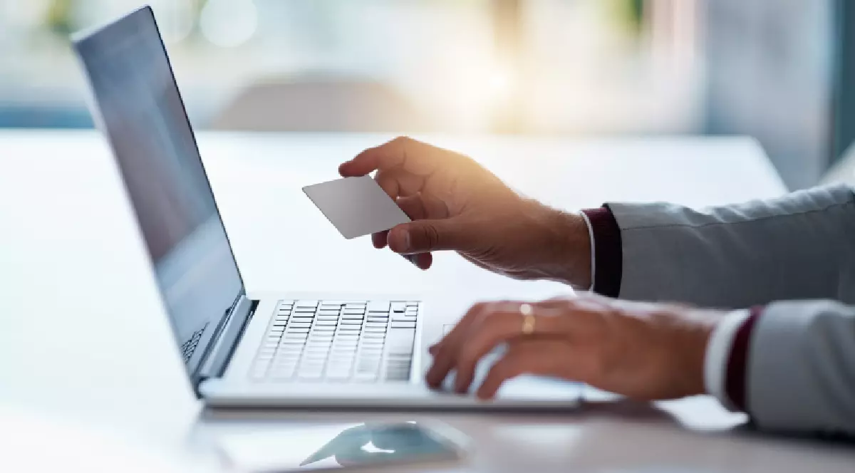 Un om de afaceri folosește laptopul și cardul de credit pentru cumpărături online