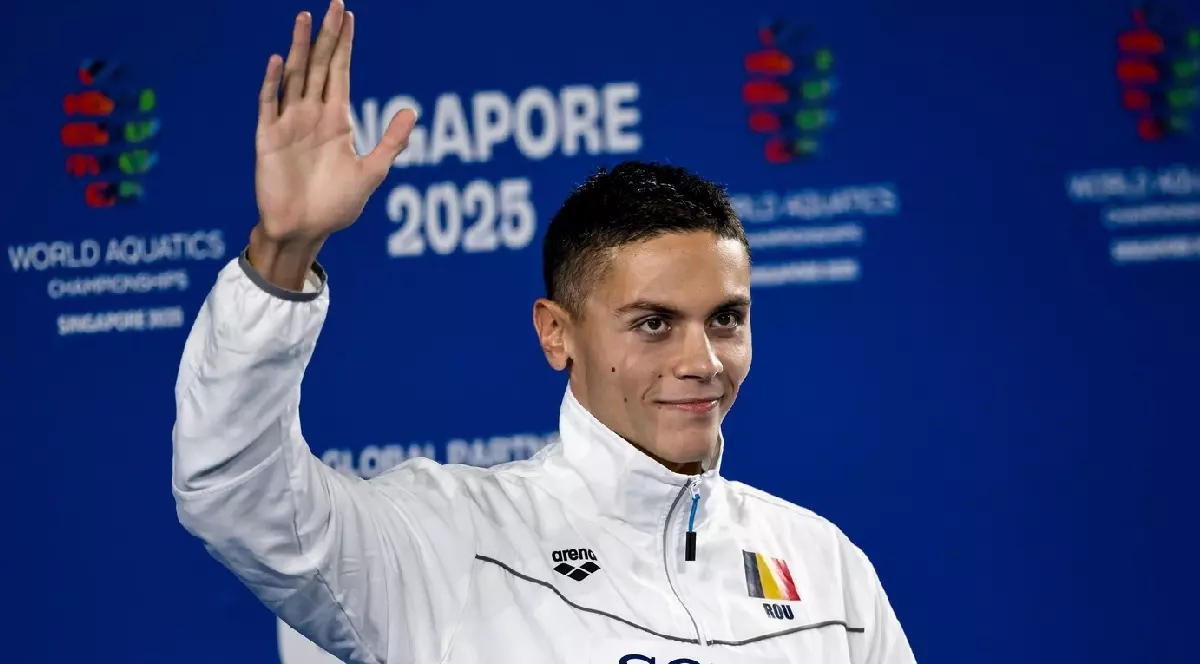 David Popovici sărbătorește după ce a câștigat medalia de aur în proba de înot 200 m liber masculin din Singapore