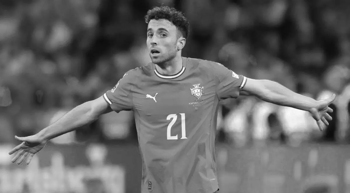 Diogo Jota, într-o poză alb-negru, îmbrăcat cu echipamentul naționalei Portugaliei, cu ambele mâinie întinse larg