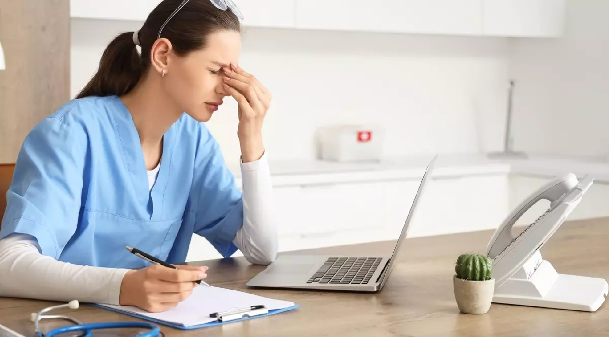 Femeie medic obosită, studiind la masa din clinică