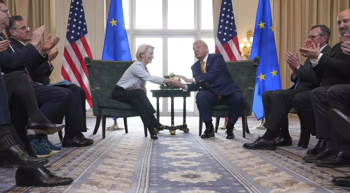Președintele Donald Trump și președinta Comisiei Europene, Ursula von der Leyen, își strâng mâinile după încheierea unui acord comercial la clubul de golf Trump Turnberry din Turnberry, Scoția, duminică, 27 iulie 2025. Donald Trump, intr-un costum inchis la culoare, cu camasa alba si cravata rosie in dungie, von der Leyen in pantaloni negri si o jacheta deschisa la culoare. membrii delegatiilor celor doua parti aplauda de pe margine