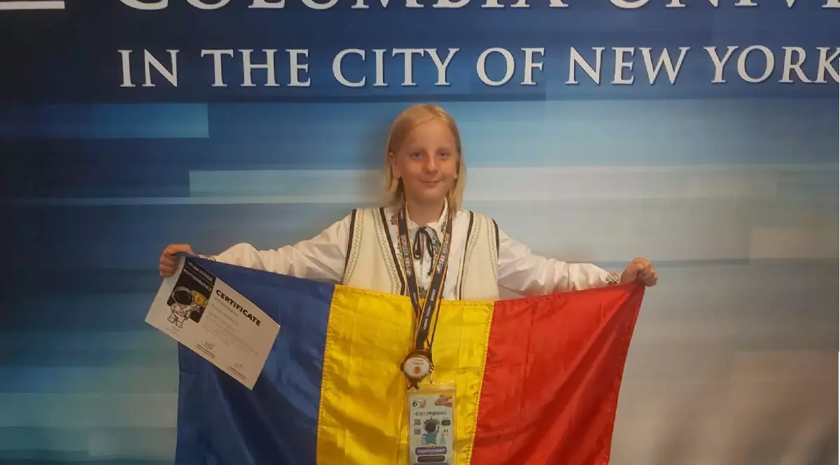 Eduard Ștefan, elev român, ține în mâini steagul României și poartă la gât medalia de aur, după ce a câștigat premiul I la Olimpiada Internațională de Matematică din SUA.