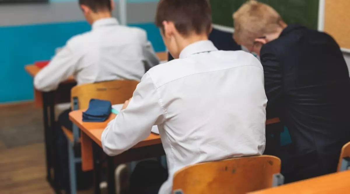 elevi care stau în bănci și suțin un examen