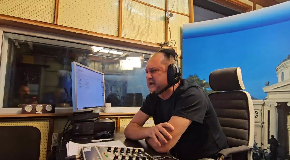 Emil Hossu-Longin în timp ce comentează finala de la Singapore, în care David Popovici a câștigat aurul, acesta stă la biroul său și este vizibil emoționat