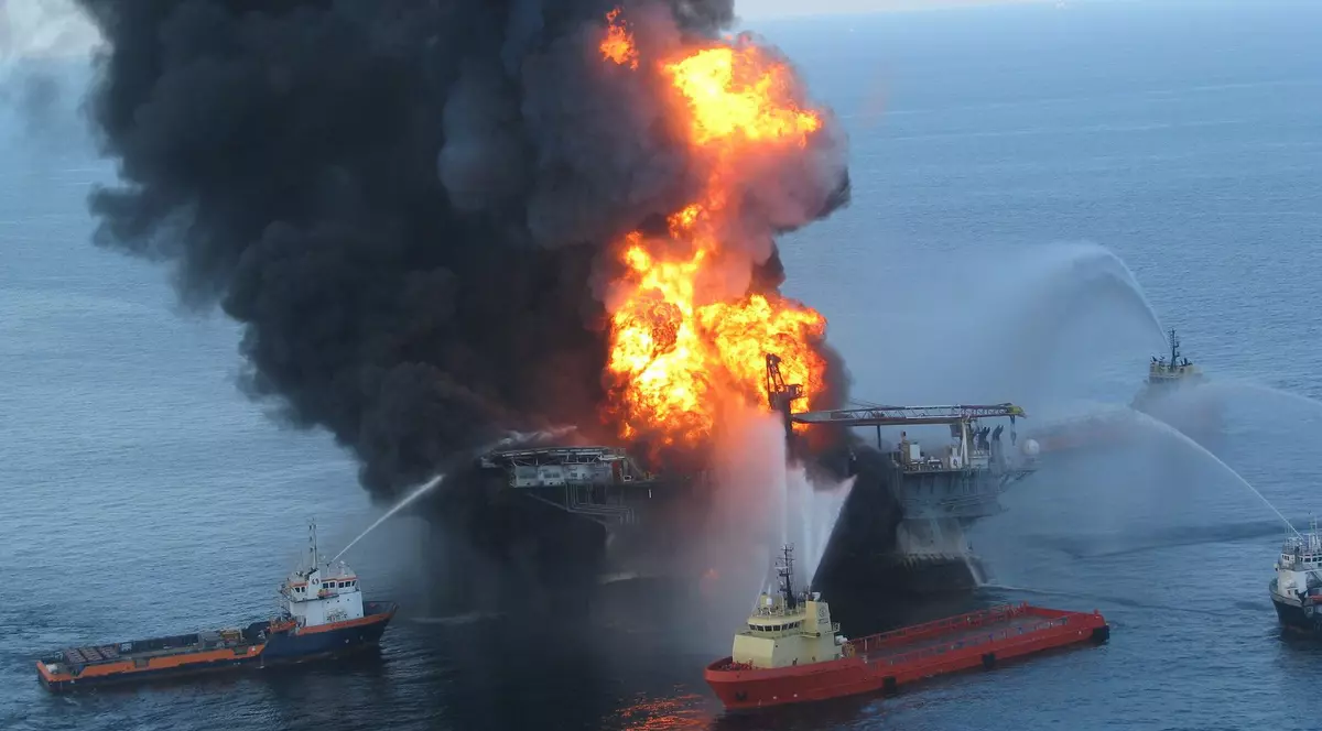 Imagine cu un petrolier cuprins de flăcări și cu mai multe nave care încearcă să stingă incendiul
