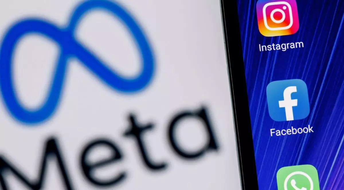 Smartphone cu pictogramele aplicațiilor Facebook, Whatsapp și Instagram pe fundalul logo-ului Meta.