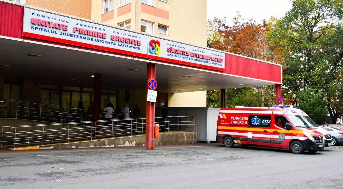 Imagine cu fațada Spitalului Județean Satu Mare, în dreapta se află o autospecială SMURD