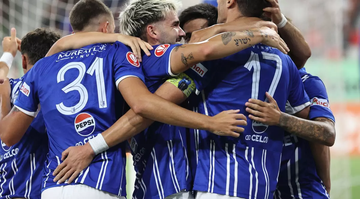 Mai mulți jucători de fotbal ai echipei Farul Constanta, imbrăcati in costumul albastru alb, se strang in brate fericiti dupa ce au castigat meciul impotriva FCSB