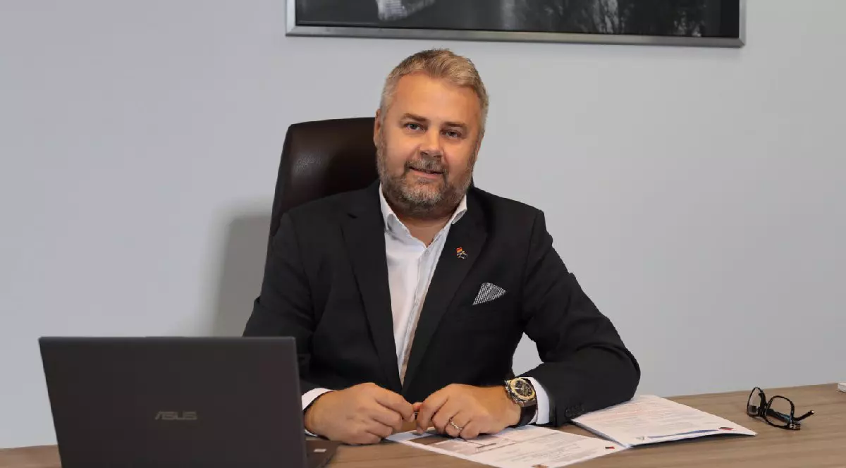 Flavius Cladoveanu, directorul Incertrans, îmbrăcat în sacou negru și cămașă albă, cu un laptop descjis în față