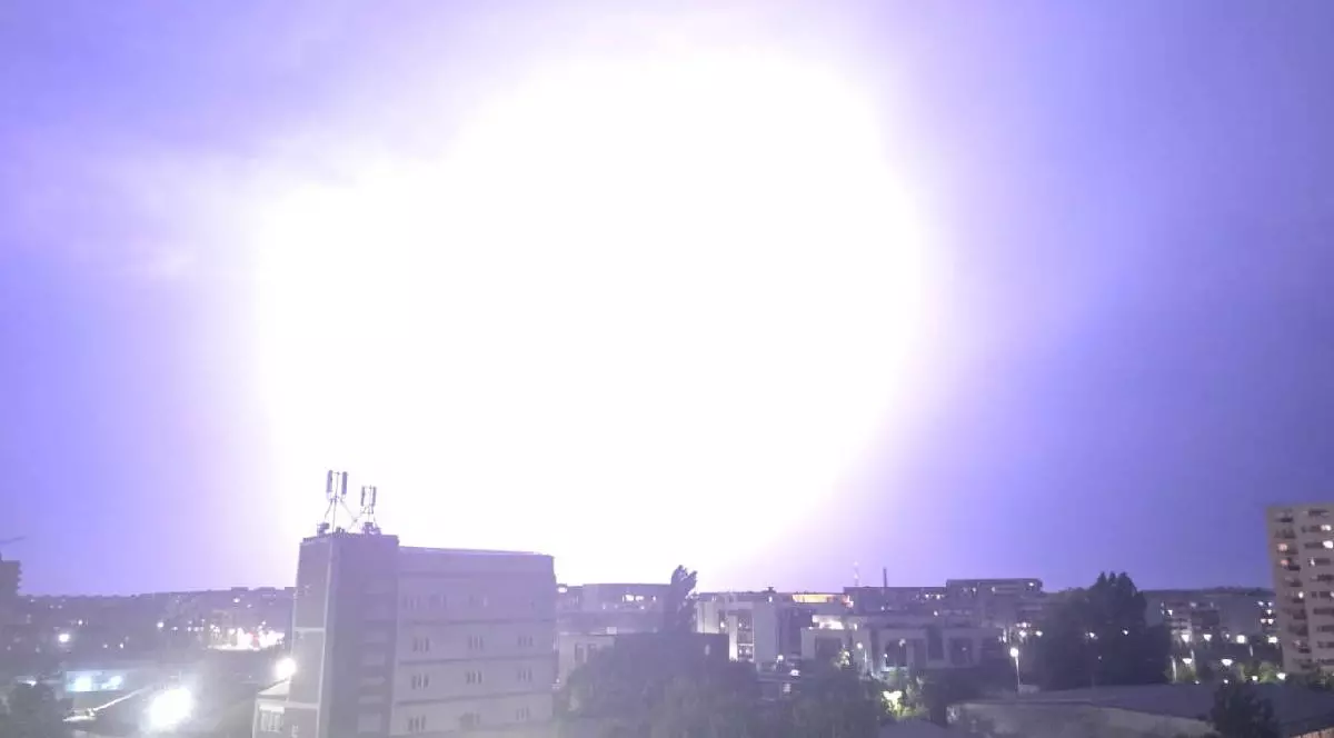 Imagine cu cerul iluminat de un fulger, în București