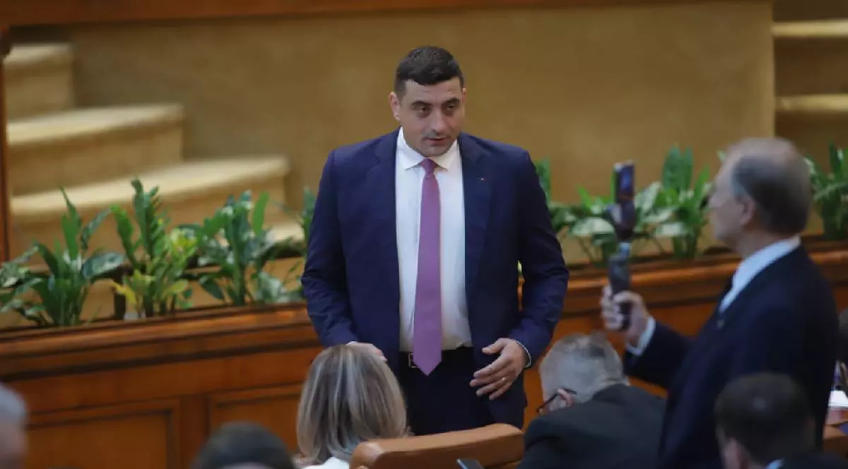 George Simion îmbrăcat în costum vorbește cu parlamentarii aflați în ședința despre moțiunea de cenzură