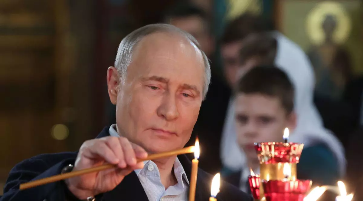 Vladimir Putin aprinde o lumânare în timpul unei slujbe dintr-o biserică din Moscova, ianuarie 2025