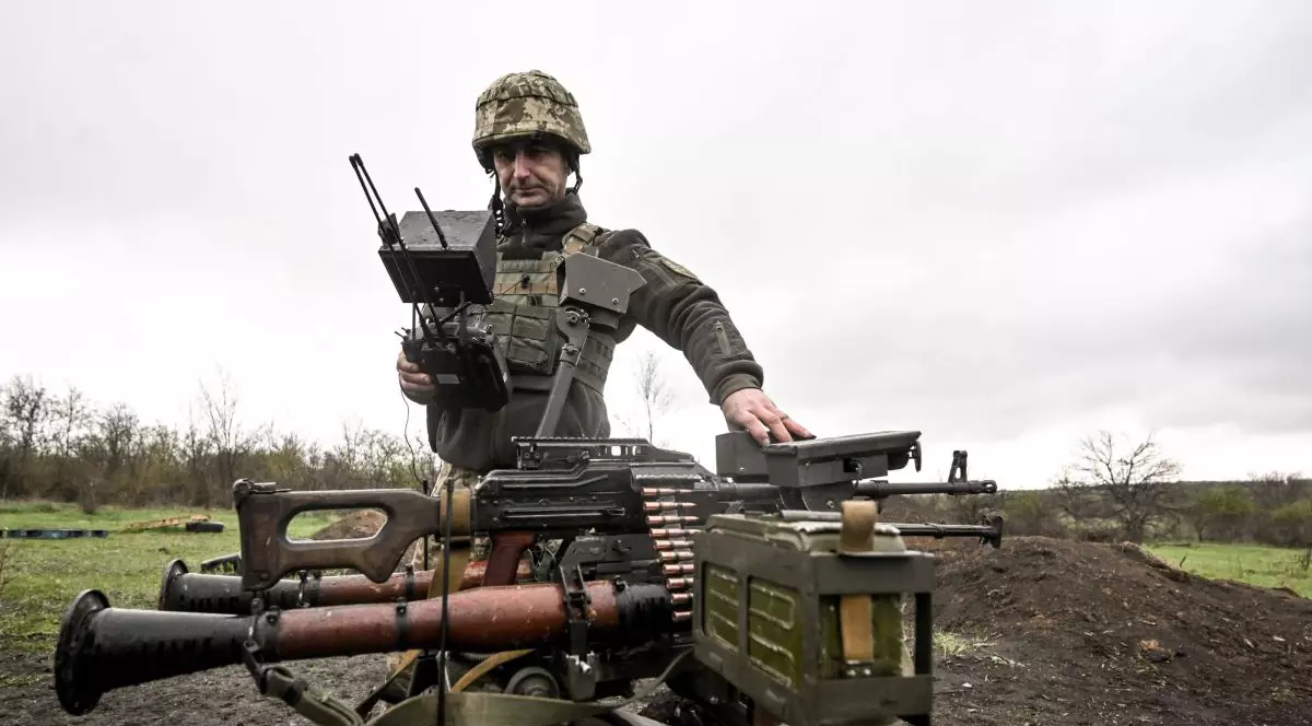 Un soldat al Brigăzii 65 Mecanizate a Forțelor Terestre Ucrainene efectuează teste pe teren ale dronei de luptă terestre Gnom-2 în Ucraina, pe 9 aprilie 2025