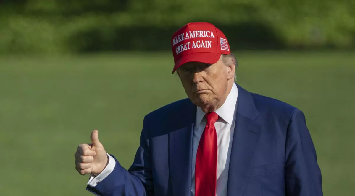 Donald Trump cu o șapcă roșie pe care scrie mesajul „Make America Great Again” și cu degetul mare ridicat Donald Trump, se îndreaptă spre Casa Albă la sosirea sa la Washington DC din New Jersey, pe 21 iunie 2025