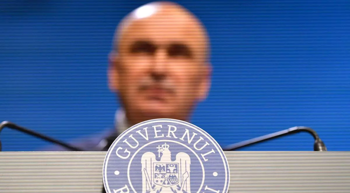 Sigla Guvernului României la pupitrul de la care vorbește Ilie Bolojan, iulie 2025