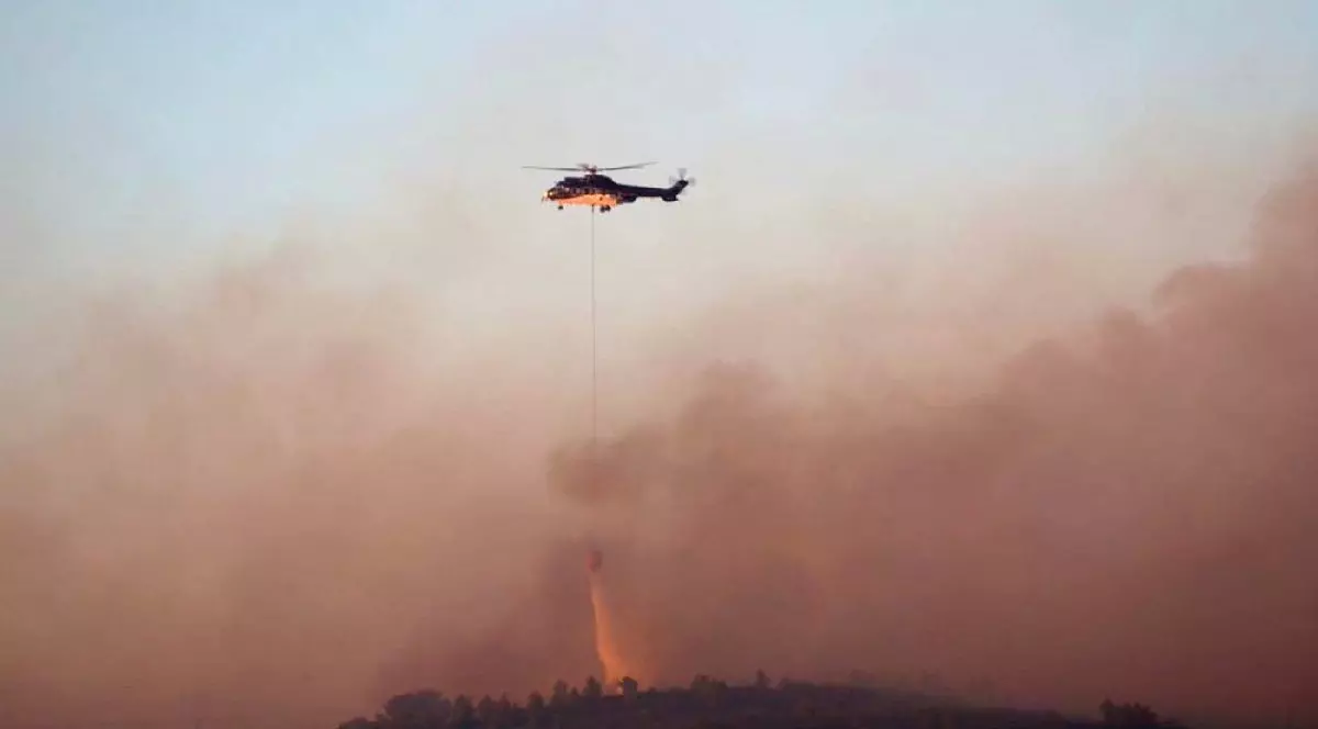 Un elicopter al pompierilor aruncă lichid pentru stingerea incendiului de vegetație din Martigues, sudul Franței.
