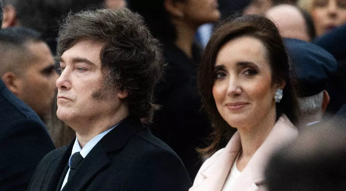 În imagine sunt Javier Milei și Victoria Villarruel, la un eveniment. El privește în față în timp ce ea privește camera foto și zâmbește