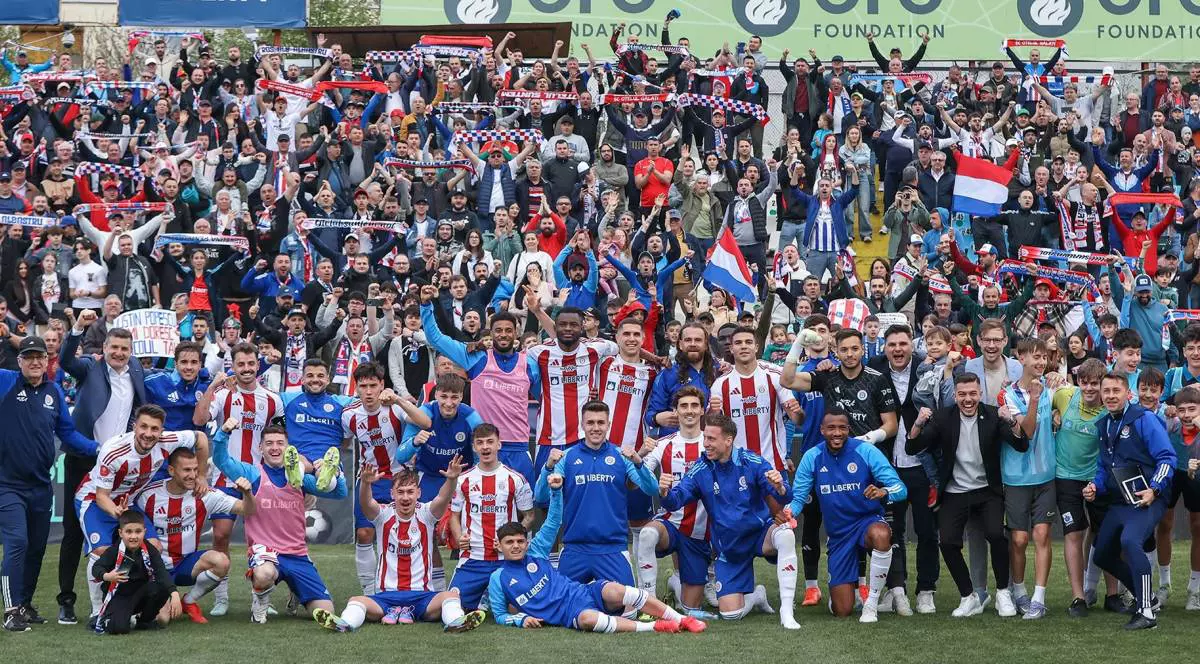 Jucătorii echipei de fotbal Oțelul Galați pe teren. Toți membrii și antrenorii s-au așezat în grup, pentru o fotografie pe teren.