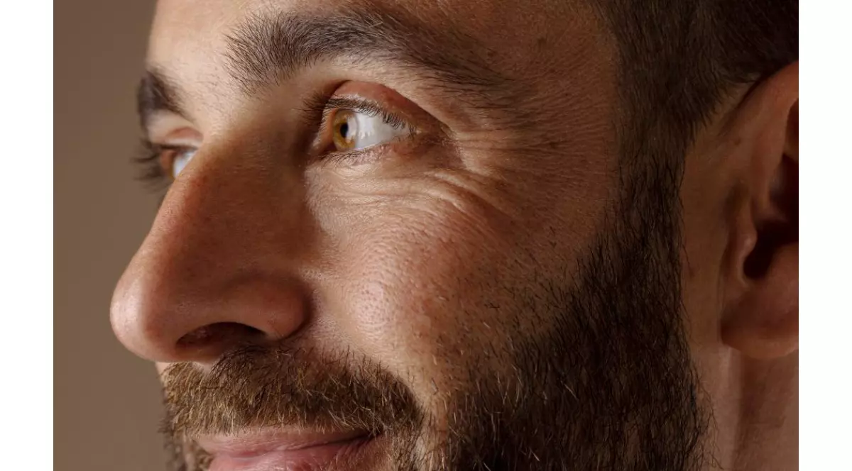 Portret barbat de varsta mijlocie, saten, cu barba si ochi de culoarea chihilmbarului. Se uita intr-o parte, zambeste