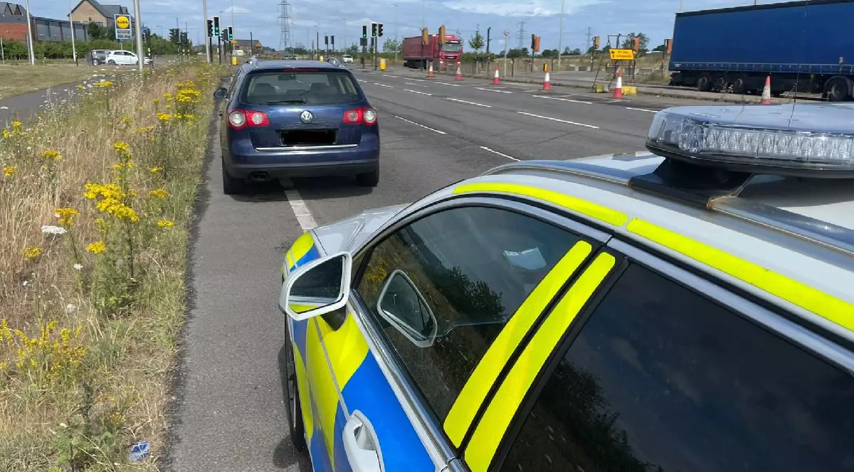 O mașină de poliție și în fața ei un autoturism Volkswagen oprit pentru control