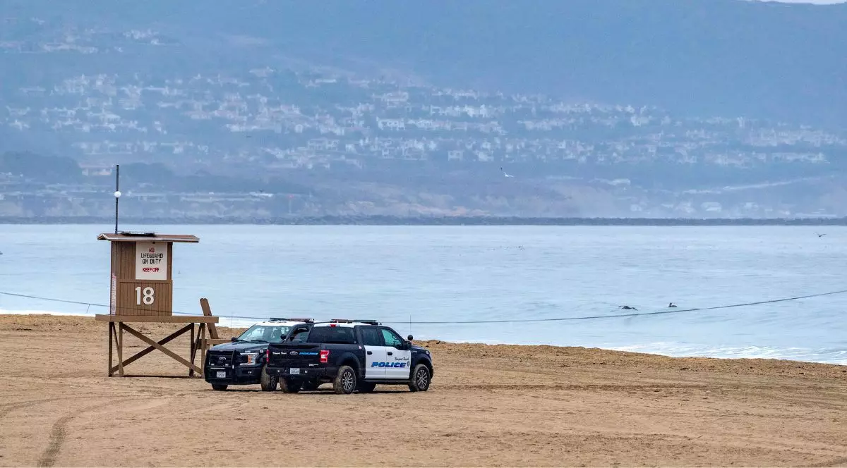 două mașini de poliție negre parcate pe o plajă din Hawaii după ce a fost emisă o avertizare de Tsunami, ianuarie 2022