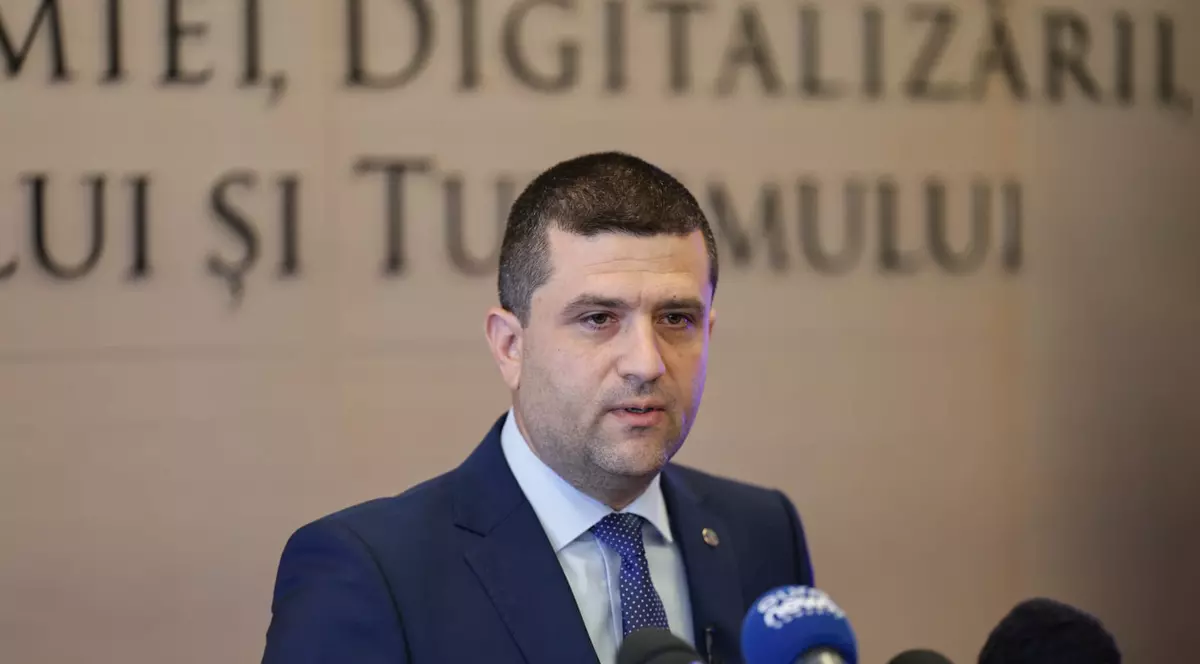 Ministrul Economiei, Radu Miruţă, in timpul unei conferinte de presa cu microfoanele televiziunilor in fata sa