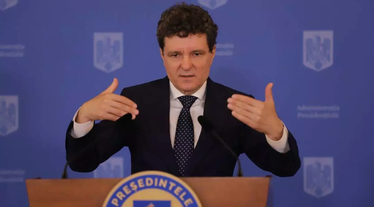 Nicușor Dan surprins gesticulând în cadrul unei conferințe de presă - luni, 14 iulie 2025. Președintele României poartă un sacou negru, o cravată neagră și o cămașă albă