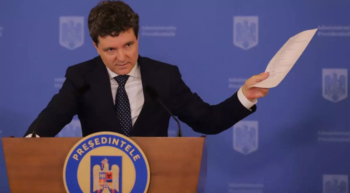 Nicușor Dan, îmbrăcat în costum negru și cămașă albă, la pupitrul Administrației Prezidențiale, pe fundal albastru