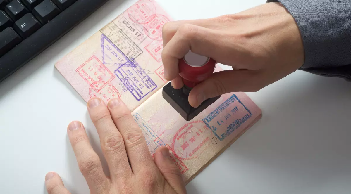 Ofiţerul de control al imigraţiei pune ştampila pe pașaport