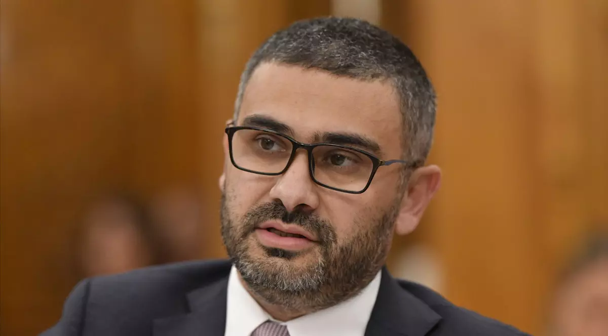 Imagine cu Petre Florin Manole. Poartă ochelari cu rame negre, o cămașă albă, un sacou negru și o cravată cu buline