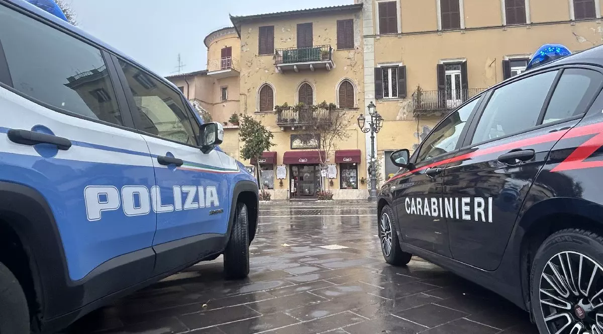 Două mașini aparținând poliției italiene și carabinierilor sunt parcate una lângă alta în fața unei clădiri din Fiuggi.