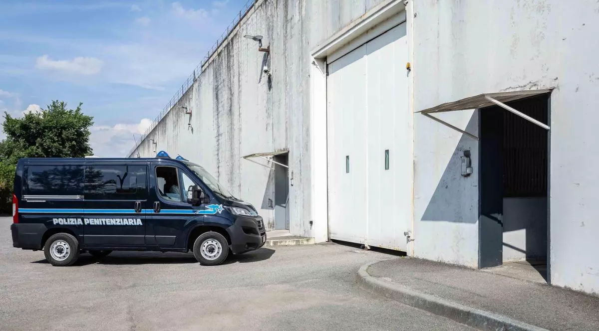 O mașină a poliției penitenciarelor stționaeză în fața intrării într-o închisoare din Italia, mai 2025