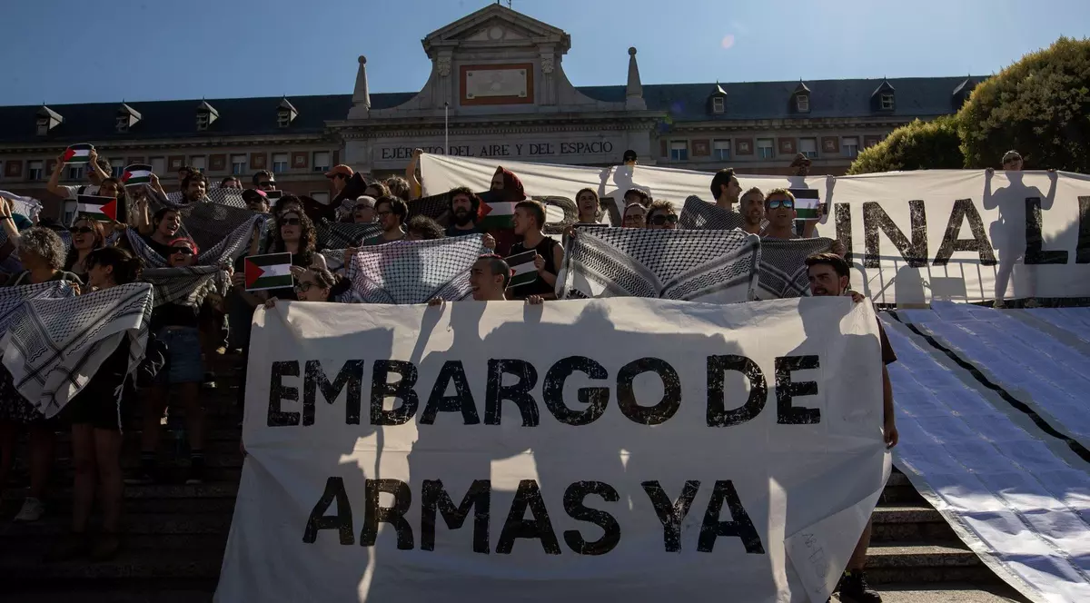 Imagine cu mai mulți protestatari care țin un afiș cu mesajul: „Embargo asupra armelor acum”