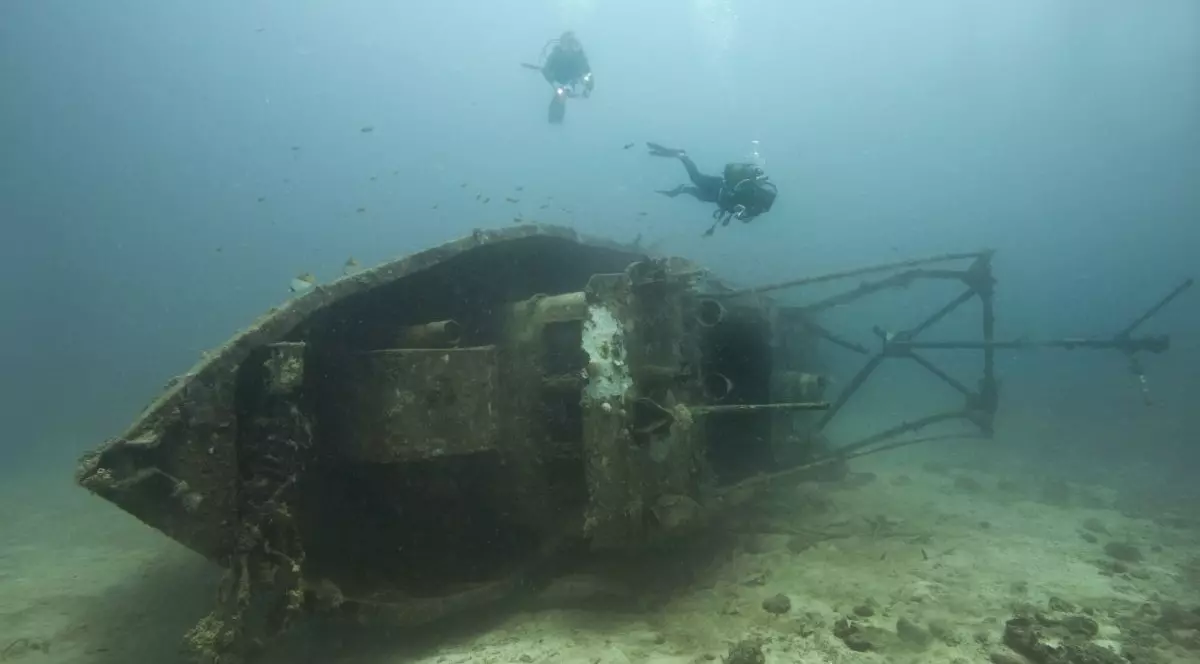 Doi scafandri înoată lângă o epavă sub apă, în Madagascar