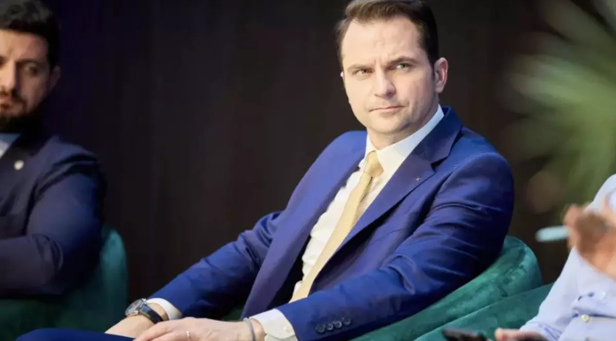 Sebastian Burduja, pe un scaun, la o conferință