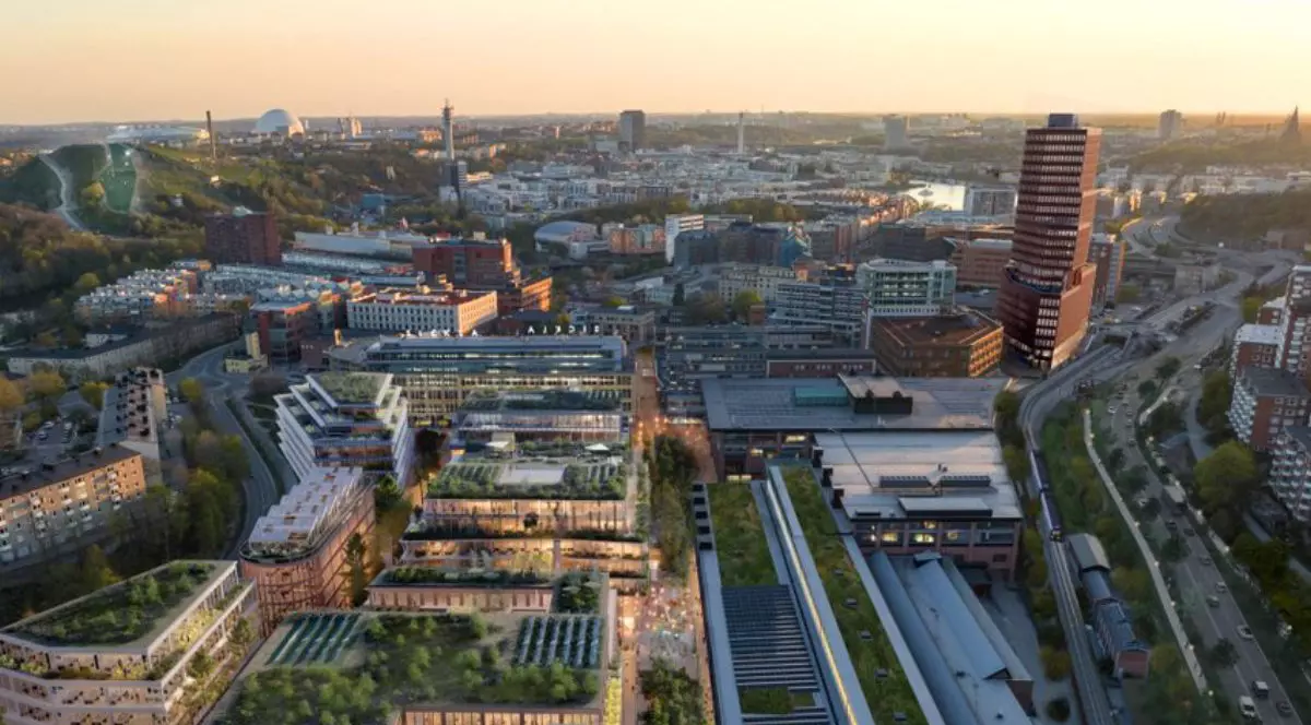 Imagine de sus cu cel mai mare oraș din lemn din lume, Stockholm Wood City, folosind lemn laminat încrucișat pentru a combate schimbările climatice. Situat în Sickla, proiectul de 1,25 miliarde de dolari va acoperi 250.000 mp cu locuințe In imagine se vad clădiri si strazi iluminate, la apus