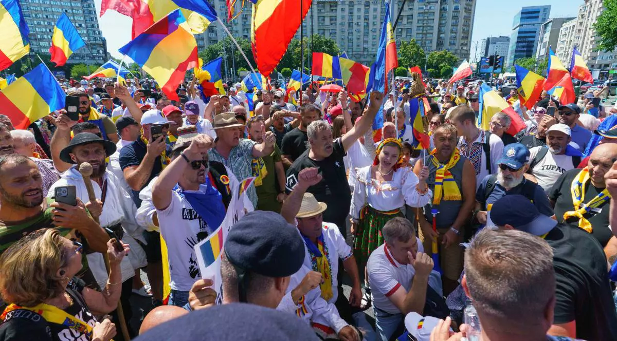 Imagine cu susținătorii lui Călin Georgescu în Piața Victoriei, pe 20 iulie 2025. Unii sunt îmbrăcați cu porturi populare și au steaguri tricolore
