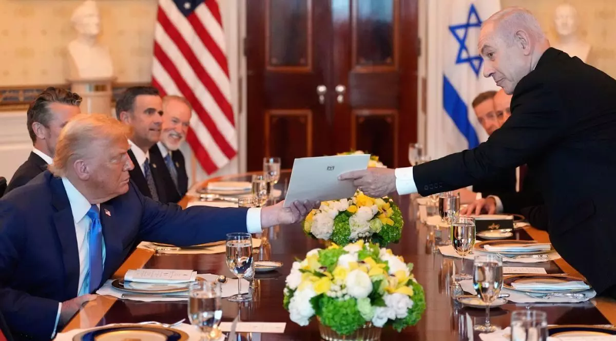 Prim-ministrul israelian Benjamin Netanyahu, în dreapta, îi înmânează președintelui Donald Trump o scrisoare cu nominalizarea la premiul Nobel pentru pace, in timpul unei întâlniri în Camera Albastră a Casei Albe, luni, 7 iulie 2025, la Washington.