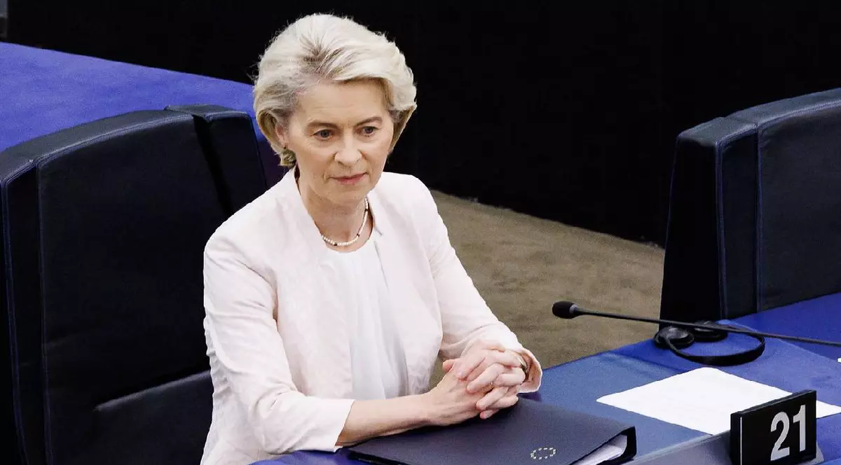 Ursula von der Leyen stă la un birou, e îmbrăcată în alb și pare că se gândește la o problemă complicată