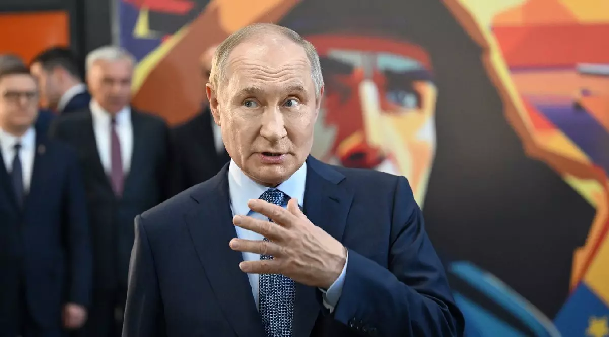 Președintele Rusiei, Vladimir Putin, îmbrăcat într-un sacou negru, cu o cămașă albă și o cravată bleumarin gesticulează, ținând mâna stânga în fața nodului cravatei sale în timpul unei vizite de lucru la combinatul siderurgic Magnitogorsk, în care inspectează un atelier de produse din industria construcțiilor de mașini, 17 iulie 2025