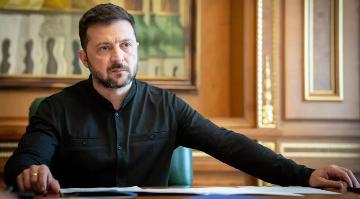 Volodimir Zelenski, președintele Ucrainei, sta asezat la biroul său, cu mainile deschise, sprijinite pe birou, imbracat într-o tunică neagră, iulie 2025