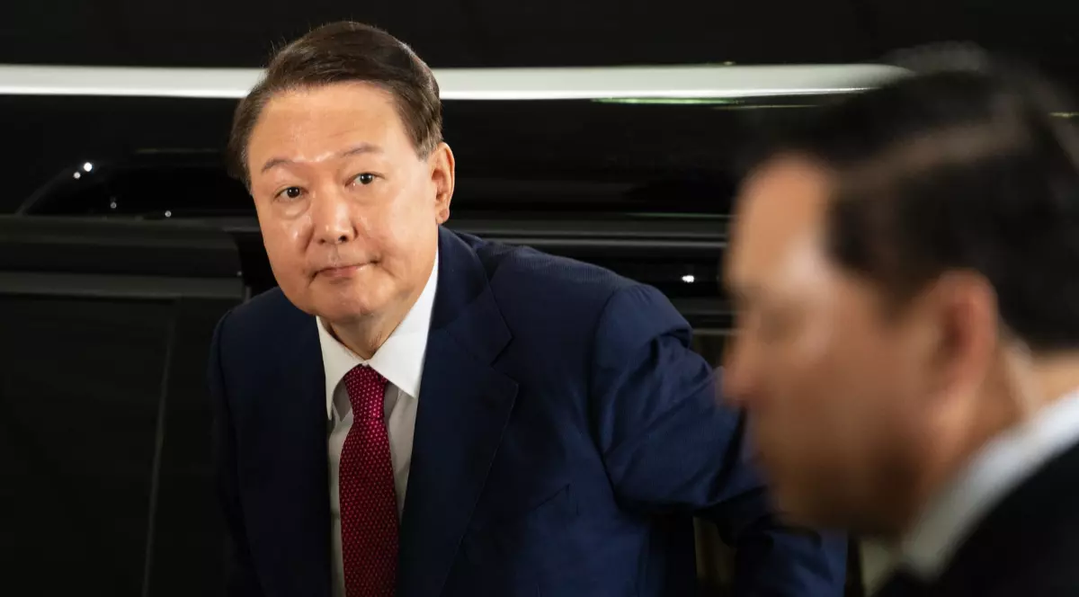 Yoon Suk Yeol, fostul președinte sud-coreean, îmbrăcat în costum, iese dintr-o mașină