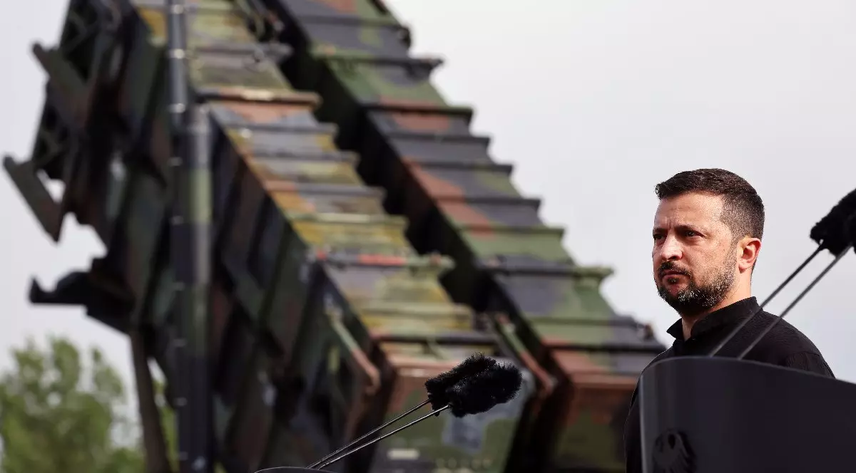 Președintele ucrainean Volodymyr Zelensky se află în fața unui sistem de rachete antiaeriene "Patriot" în timpul vizitei sale la o zonă de antrenament militar. 11 iunie 2024