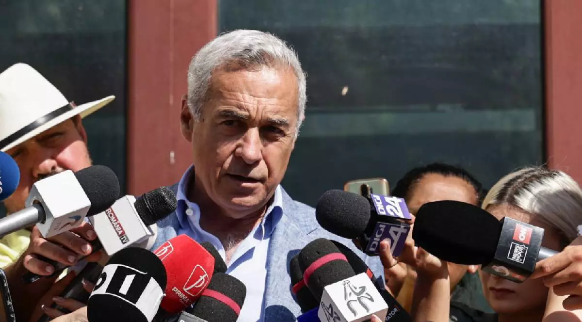 Călin Georgescu vorbește cu jurnaliștii la ieșirea din Parchet. e îmbrăcat cu un costum și are o figură gravă
